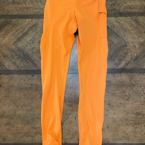 Gymshark women’s tights size XS bright orange color with stirrup bottoms.